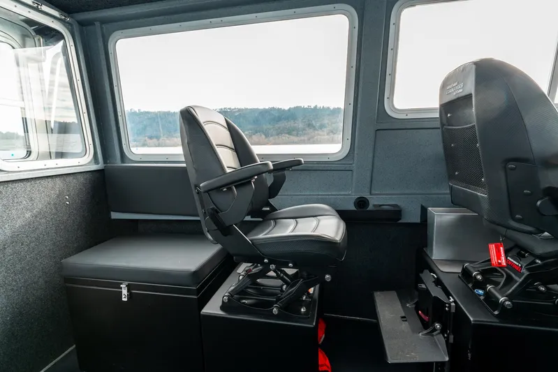  Yacht Photos Pics Interior of 2023 Liquid Metal Marine Maquinna Crew boat with black seating and control panel.