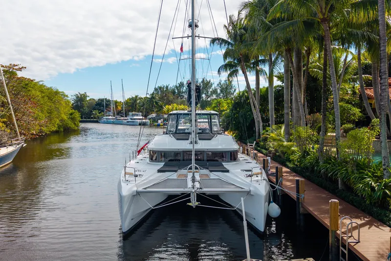 Going Deeper Yacht Photos Pics 2024 Lagoon 51 catamaran docked in a tropical marina setting.
