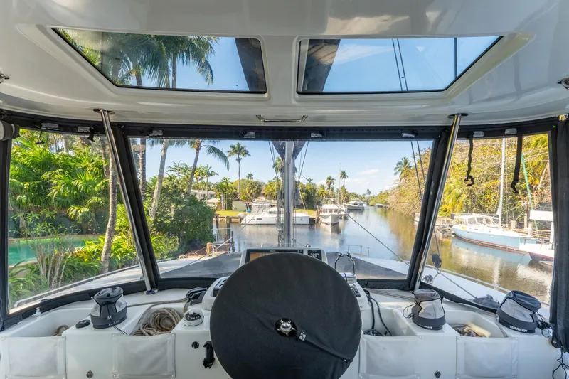 Going Deeper Yacht Photos Pics Cockpit view from 2024 Lagoon 51 yacht, overlooking a serene tropical marina.