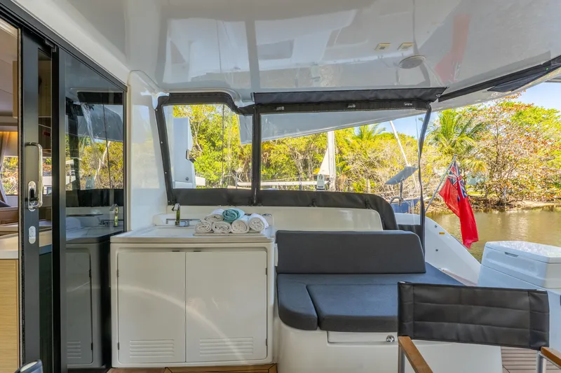 Going Deeper Yacht Photos Pics 2024 Lagoon 51 yacht interior with seating, towels, and scenic outdoor view.