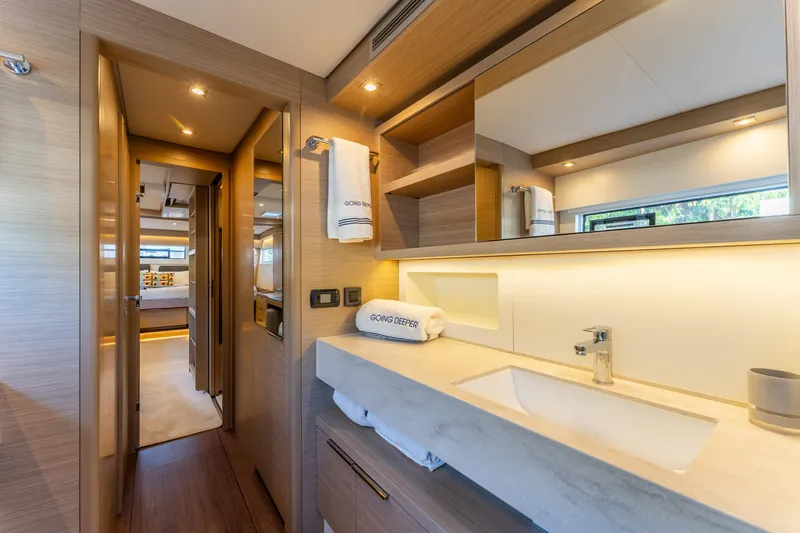Going Deeper Yacht Photos Pics Luxurious interior of 2024 Lagoon 51 yacht, featuring modern bathroom and cozy bedroom.