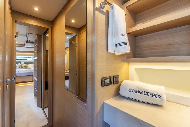 Going Deeper Yacht Photos Pics Luxurious interior of 2024 Lagoon 51 yacht with elegant wood finishes and plush towels.