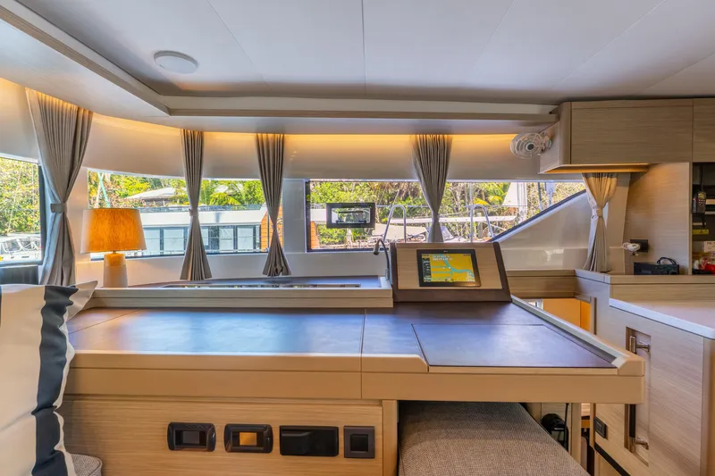 Going Deeper Yacht Photos Pics Luxurious interior of 2024 Lagoon 51 yacht with navigation station and panoramic windows.