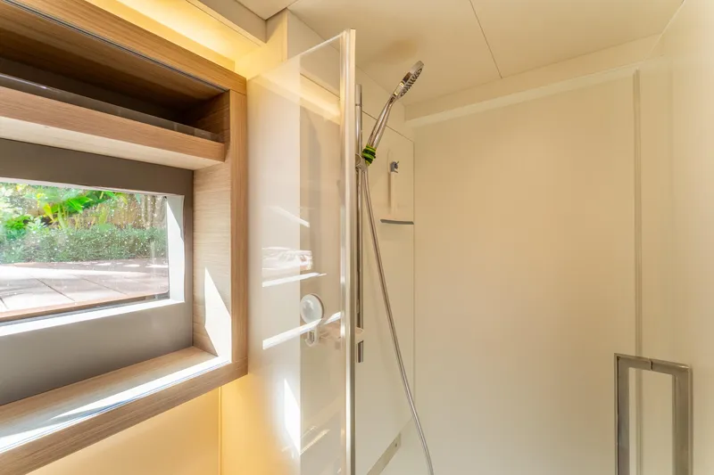 Going Deeper Yacht Photos Pics Modern shower area in 2024 Lagoon 51 yacht, featuring sleek design and natural light.
