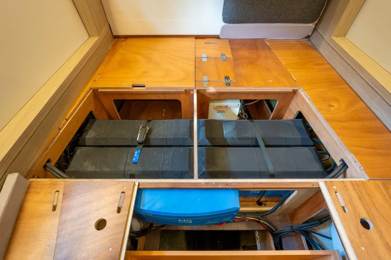 Going Deeper Yacht Photos Pics 2024 Lagoon 51 yacht interior showing battery storage compartment with wooden panels.