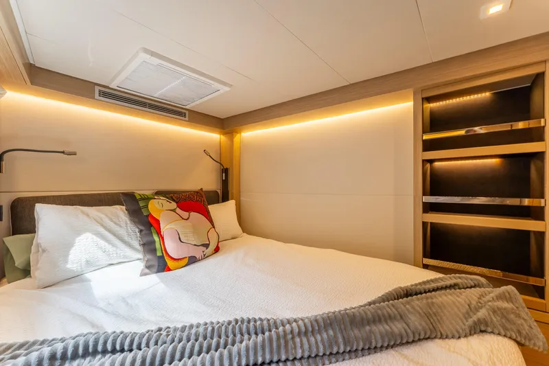 Going Deeper Yacht Photos Pics Luxurious bedroom interior of 2024 Lagoon 51 yacht with modern lighting and cozy bedding.