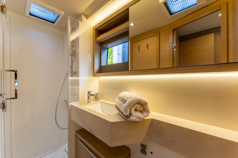 Going Deeper Yacht Photos Pics Luxurious bathroom interior of 2024 Lagoon 51 yacht with modern fixtures and ambient lighting.