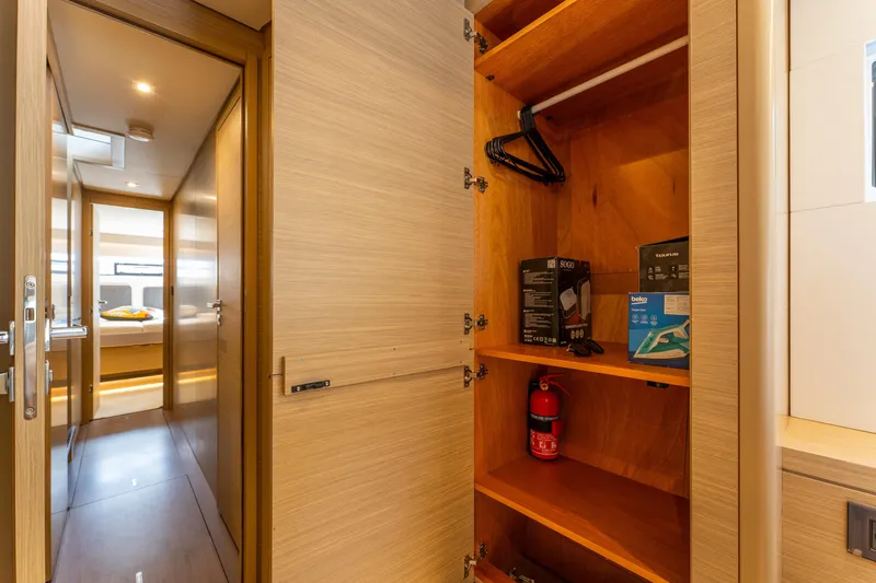 Going Deeper Yacht Photos Pics 2024 Lagoon 51 yacht interior with open closet, fire extinguisher, and hallway view.