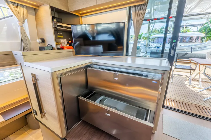 Going Deeper Yacht Photos Pics Modern kitchen area on 2024 Lagoon 51 yacht with stainless steel appliances and outdoor view.