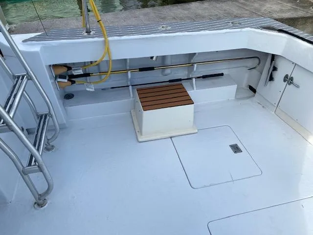 Cost Of Living Yacht Photos Pics 1985 Bertram 38 Convertible boat deck with fishing rod storage and seating.