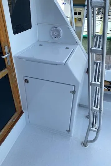 Cost Of Living Yacht Photos Pics 1985 Bertram 38 Convertible boat interior with storage cabinet and ladder.