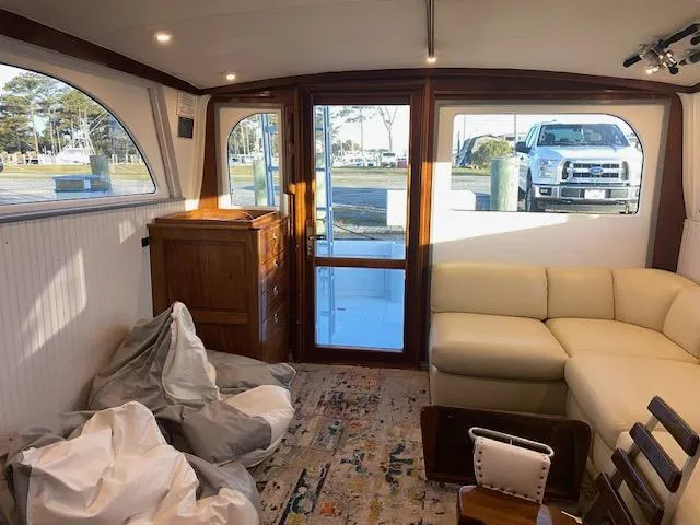 Cost Of Living Yacht Photos Pics Interior of 1985 Bertram 38 Convertible yacht with beige sofa and wooden accents.