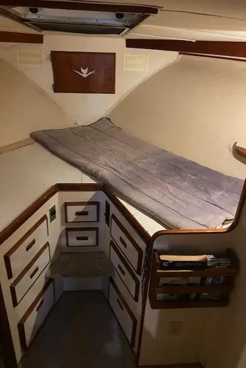 Cost Of Living Yacht Photos Pics 1985 Bertram 38 Convertible cabin interior with bed and storage drawers.