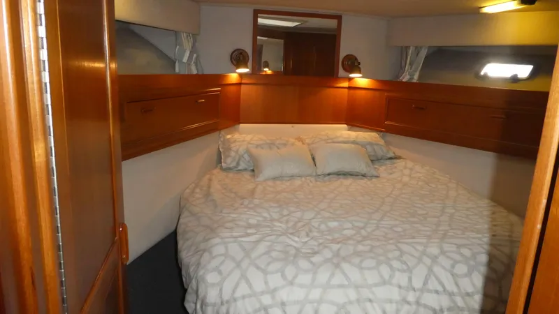  Yacht Photos Pics Cozy bedroom in 1995 Riviera Convertible yacht with wooden cabinets and soft lighting.