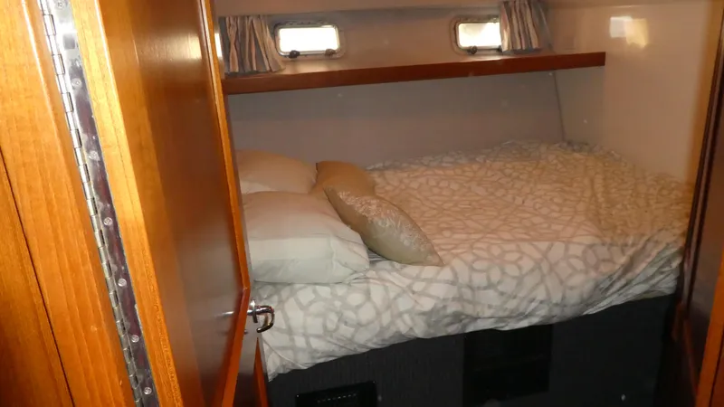  Yacht Photos Pics Cozy cabin interior of 1995 Riviera Convertible with bed and wooden accents.