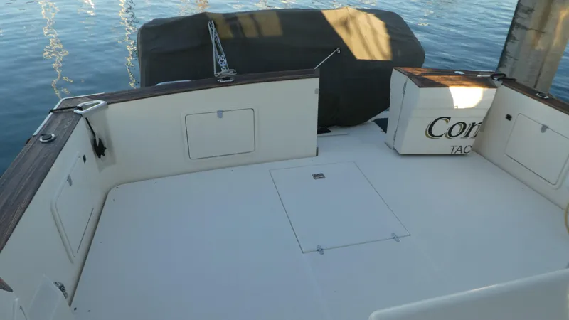  Yacht Photos Pics 1995 Riviera Convertible boat deck with storage compartments, docked by calm water.