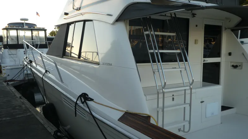  Yacht Photos Pics 1995 Riviera Convertible yacht docked, featuring sleek design and ladder access.