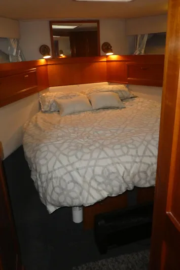  Yacht Photos Pics Cozy bedroom in 1995 Riviera Convertible yacht with elegant bedding and warm lighting.