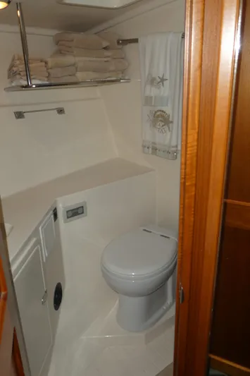  Yacht Photos Pics 1995 Riviera Convertible yacht bathroom with toilet, towels, and wooden accents.