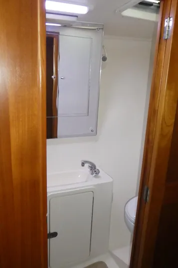  Yacht Photos Pics 1995 Riviera Convertible bathroom with wooden door, sink, and mirror.