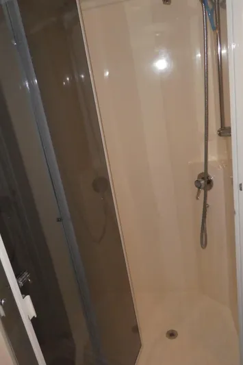  Yacht Photos Pics Shower area inside a 1995 Riviera Convertible boat, featuring a handheld showerhead.