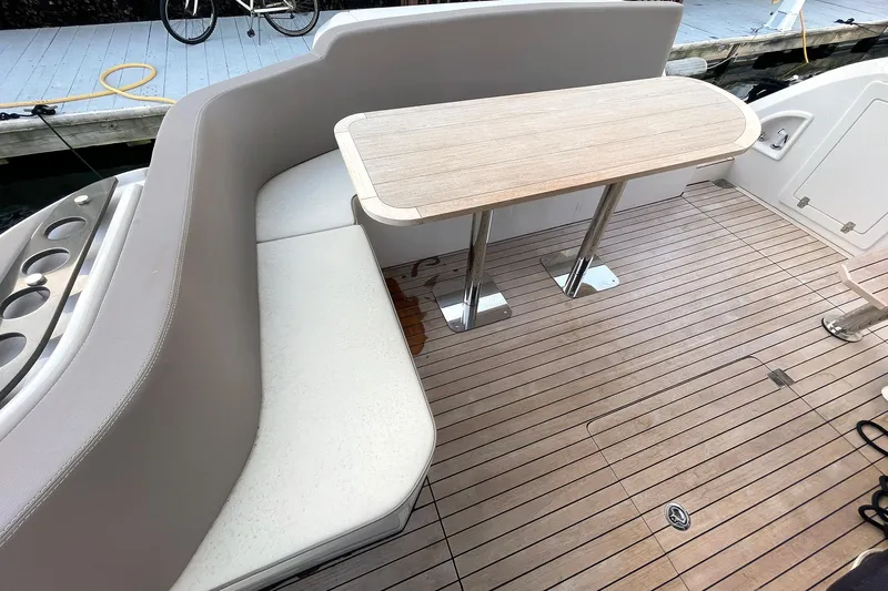  Yacht Photos Pics Luxury seating area on 2024 Sessa Marine F42 Flybridge yacht with wooden table.
