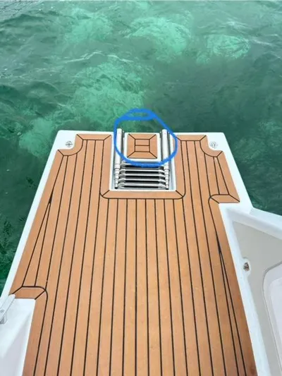 Vision 444es Yacht Photos Pics Vision 444 2025 boat deck with wooden finish and ladder, overlooking clear water.