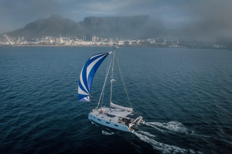 Vision 444es Yacht Photos Pics Sailing yacht Vision 444 (2025) on open sea with coastal city and mountains in background.