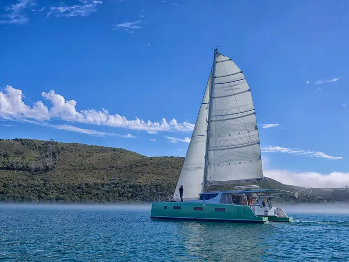 Vision 444es Yacht Photos Pics Sailing catamaran Vision 444 ES 2026 on serene lake with clear blue sky.