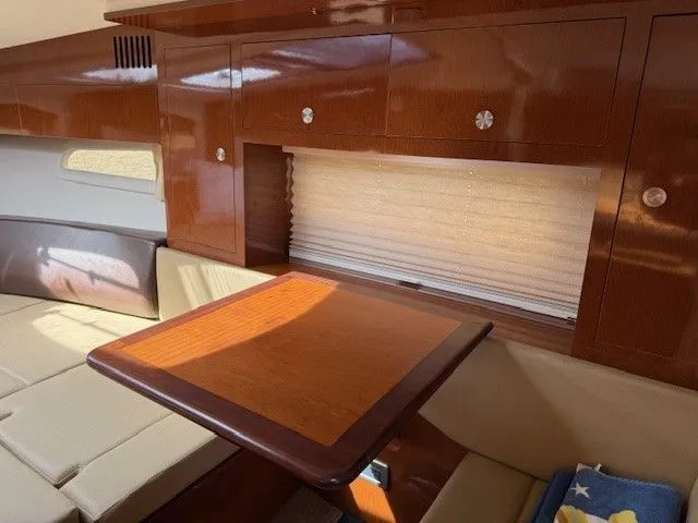 Bella Vida Yacht Photos Pics Interior of 2014 Sea Ray 310 Sundancer with wooden table and beige seating.