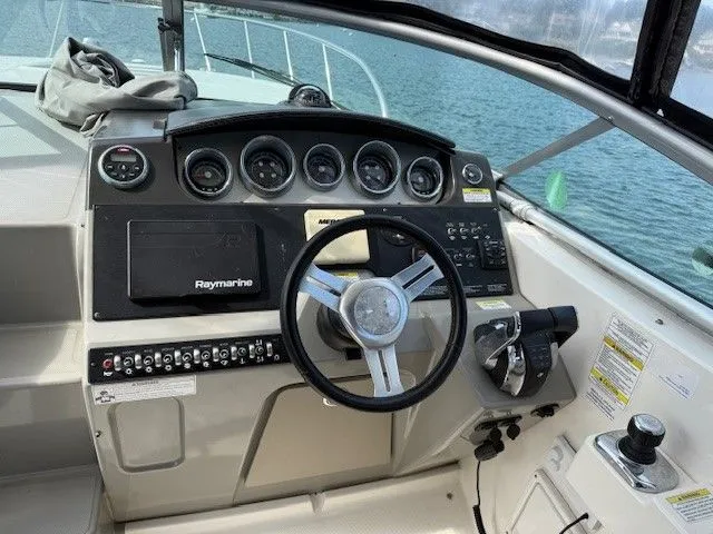 Bella Vida Yacht Photos Pics 2014 Sea Ray 310 Sundancer helm with Raymarine navigation, steering wheel, and control panel.