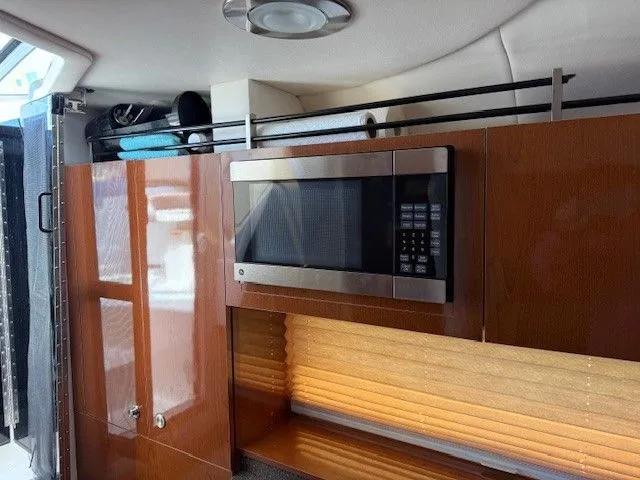 Bella Vida Yacht Photos Pics Interior of 2014 Sea Ray 310 Sundancer with microwave and wooden cabinetry.