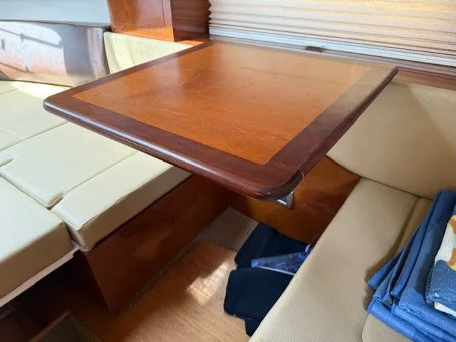 Bella Vida Yacht Photos Pics Interior of 2014 Sea Ray 310 Sundancer with wooden table and beige seating.