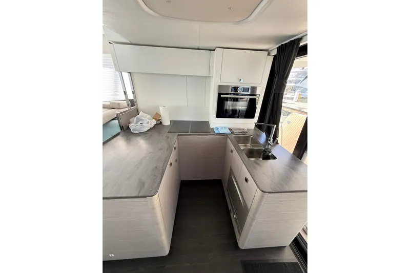  Yacht Photos Pics Modern kitchen interior of 2024 Fountaine Pajot MY 44 yacht, featuring sleek countertops and appliances.