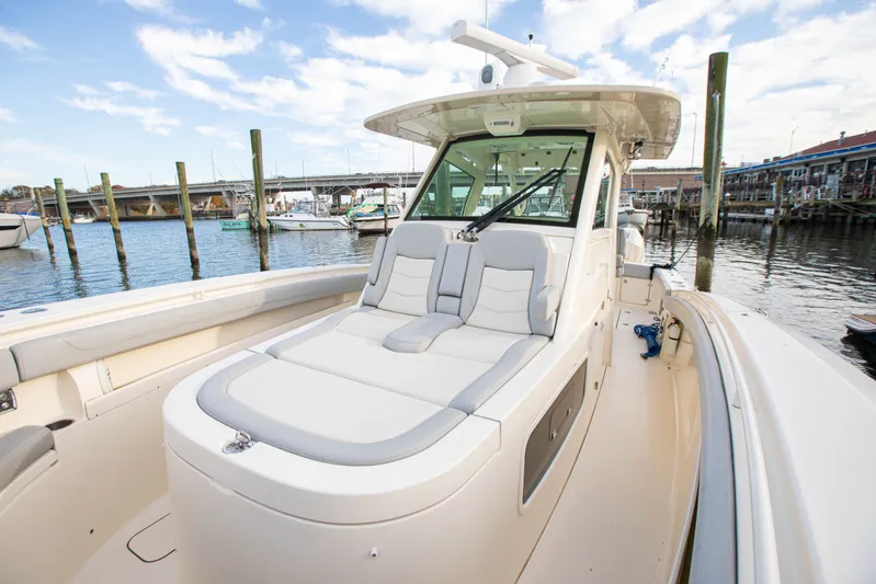  Yacht Photos Pics 2019 Scout 355 LXF boat docked at marina, featuring sleek design and comfortable seating.