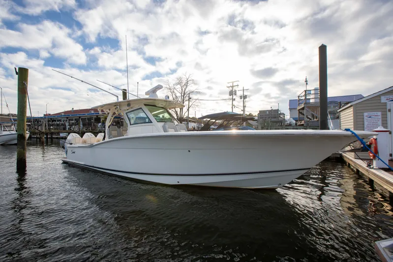  Yacht Photos Pics 2019 Scout 355 LXF boat docked at marina under cloudy sky.