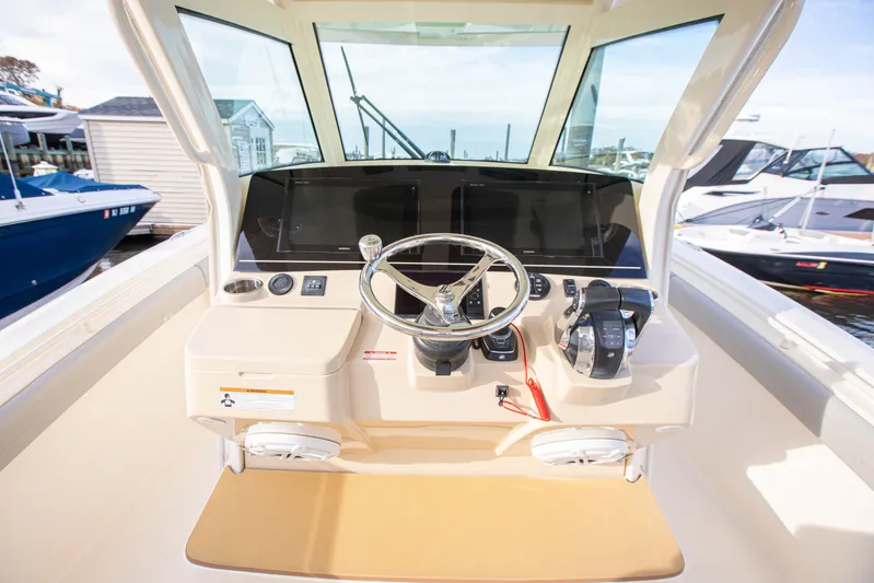  Yacht Photos Pics 2019 Scout 355 LXF boat helm with steering wheel and controls, docked at marina.