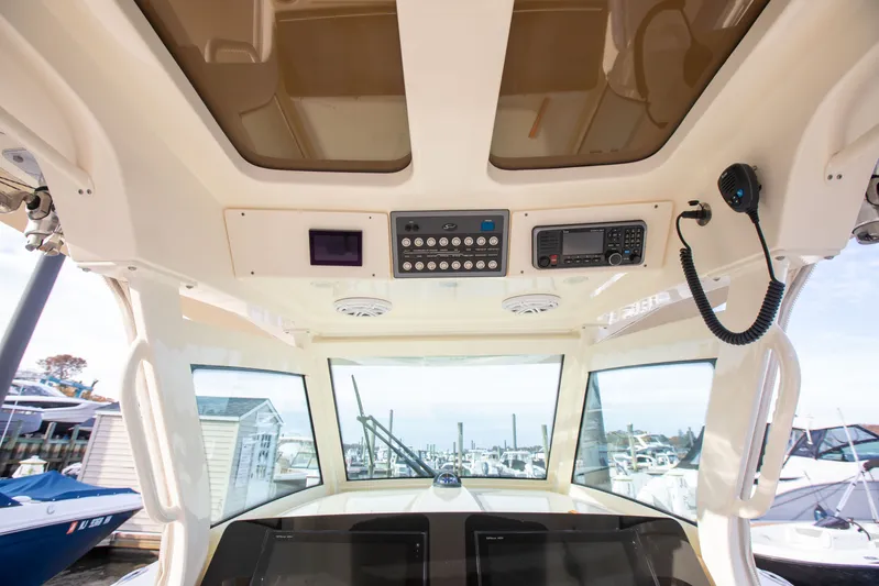  Yacht Photos Pics Interior view of 2019 Scout 355 LXF boat cockpit with control panel and windows.