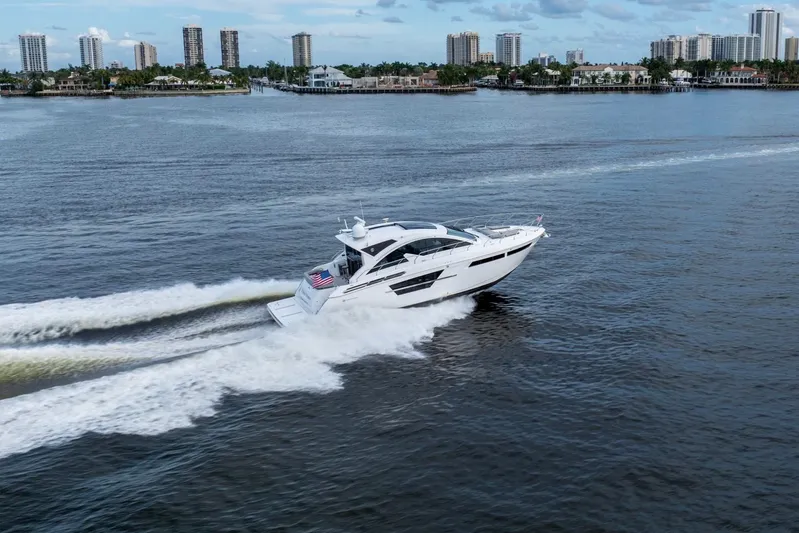 Tropical Dreamer Yacht Photos Pics 2022 Cruisers Yachts 54 Cantius cruising on a scenic waterway with city skyline.