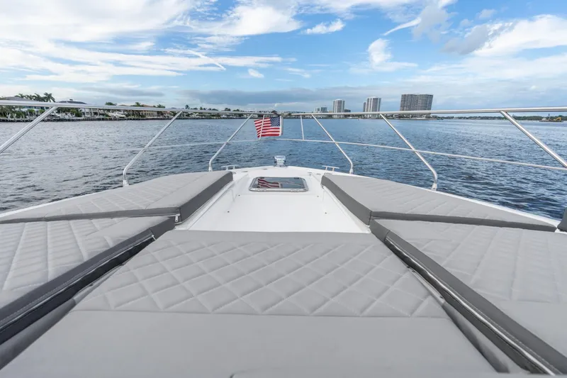 Tropical Dreamer Yacht Photos Pics 2022 Cruisers Yachts 54 Cantius on water, featuring spacious deck and American flag.
