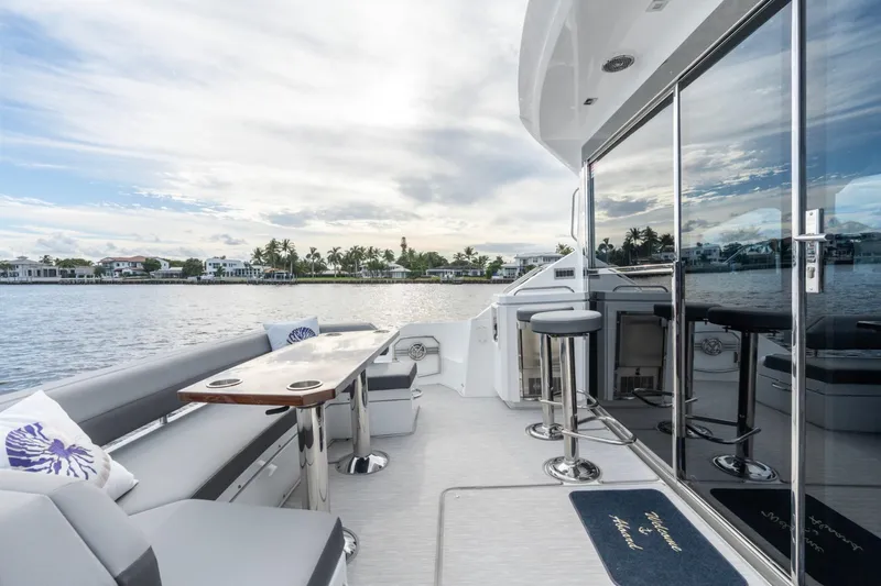 Tropical Dreamer Yacht Photos Pics 2022 Cruisers Yachts 54 Cantius luxury deck with seating and scenic waterfront view.