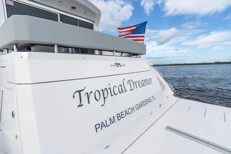 Tropical Dreamer Yacht Photos Pics 2022 Cruisers Yachts 54 Cantius, "Tropical Dreamer," on water with American flag.