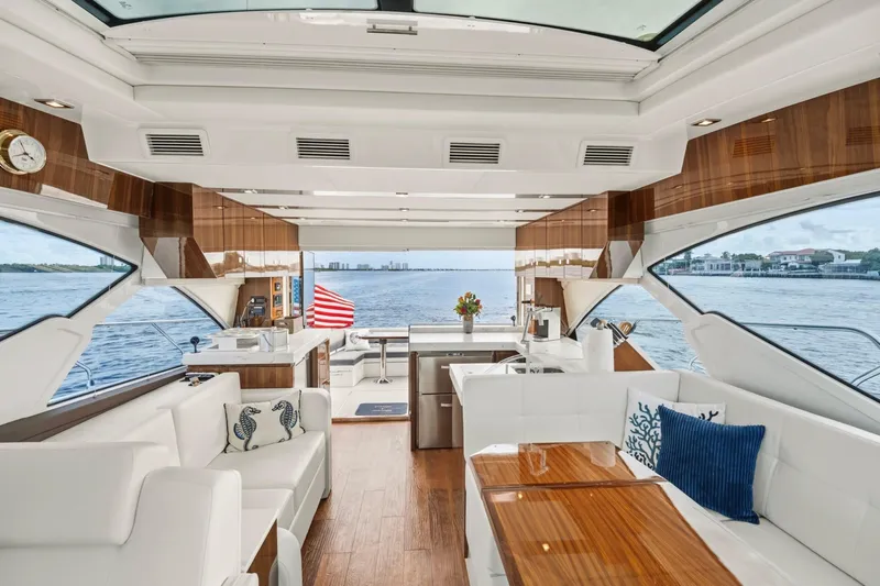 Tropical Dreamer Yacht Photos Pics Luxurious interior of 2022 Cruisers Yachts 54 Cantius with elegant seating and scenic ocean view.