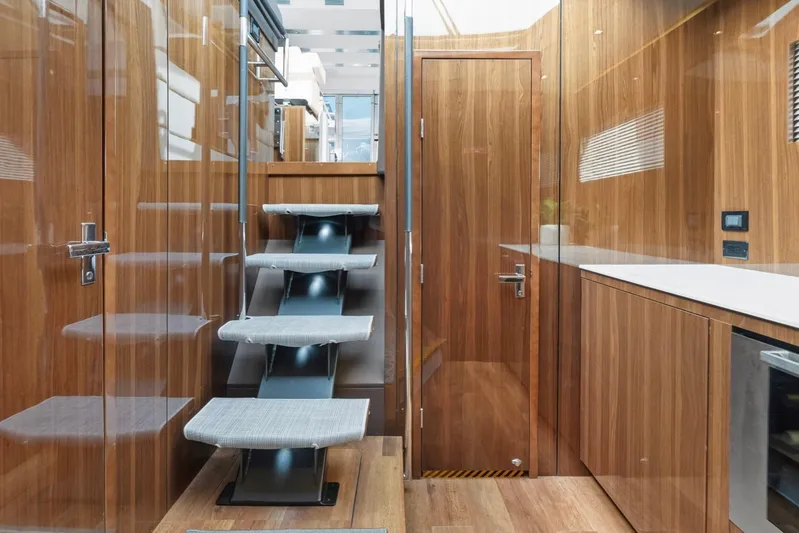 Tropical Dreamer Yacht Photos Pics Luxurious interior of 2022 Cruisers Yachts 54 Cantius with modern wooden finishes and sleek staircase.