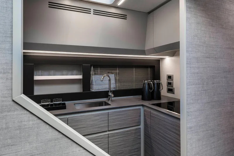  Yacht Photos Pics Modern kitchen interior of 2025 Pershing 6X yacht, featuring sleek cabinetry and appliances.