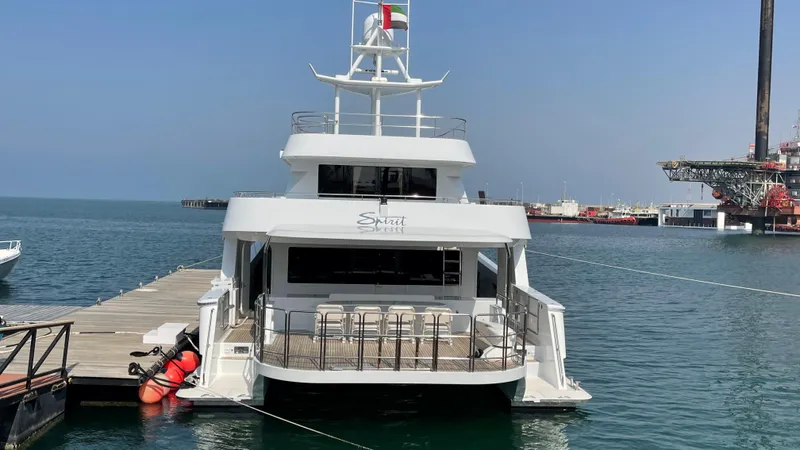 Spirit Yacht Photos Pics Custom Austral Yachts Wavepiercer 1999 docked at marina, calm sea, clear sky.