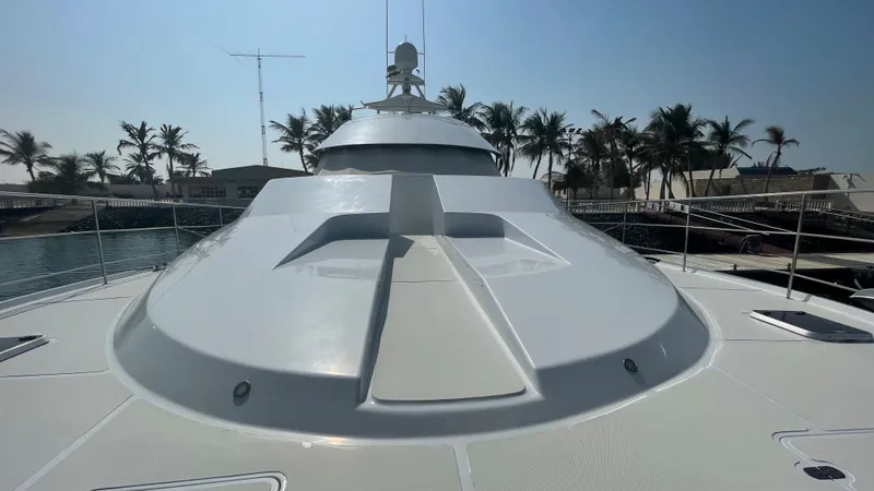 Spirit Yacht Photos Pics Custom 1999 Austral Yachts Wavepiercer on water, surrounded by palm trees under clear sky.