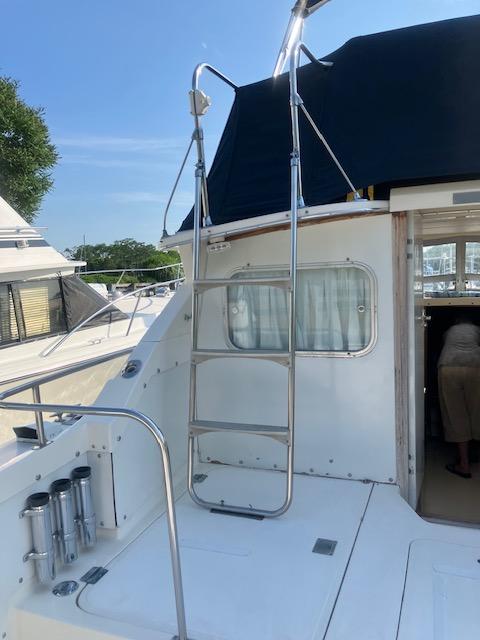 1974 Bertram 28 Flybridge boat with ladder and open cabin door.