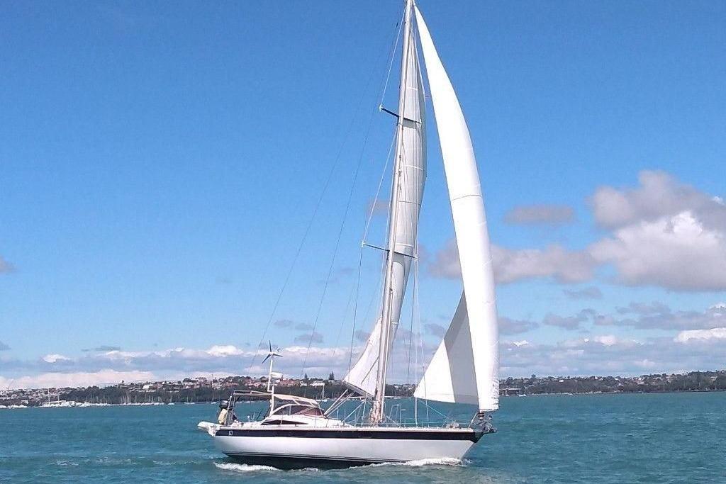 Sailing yacht Express 44 (1983) on open water under clear blue sky.