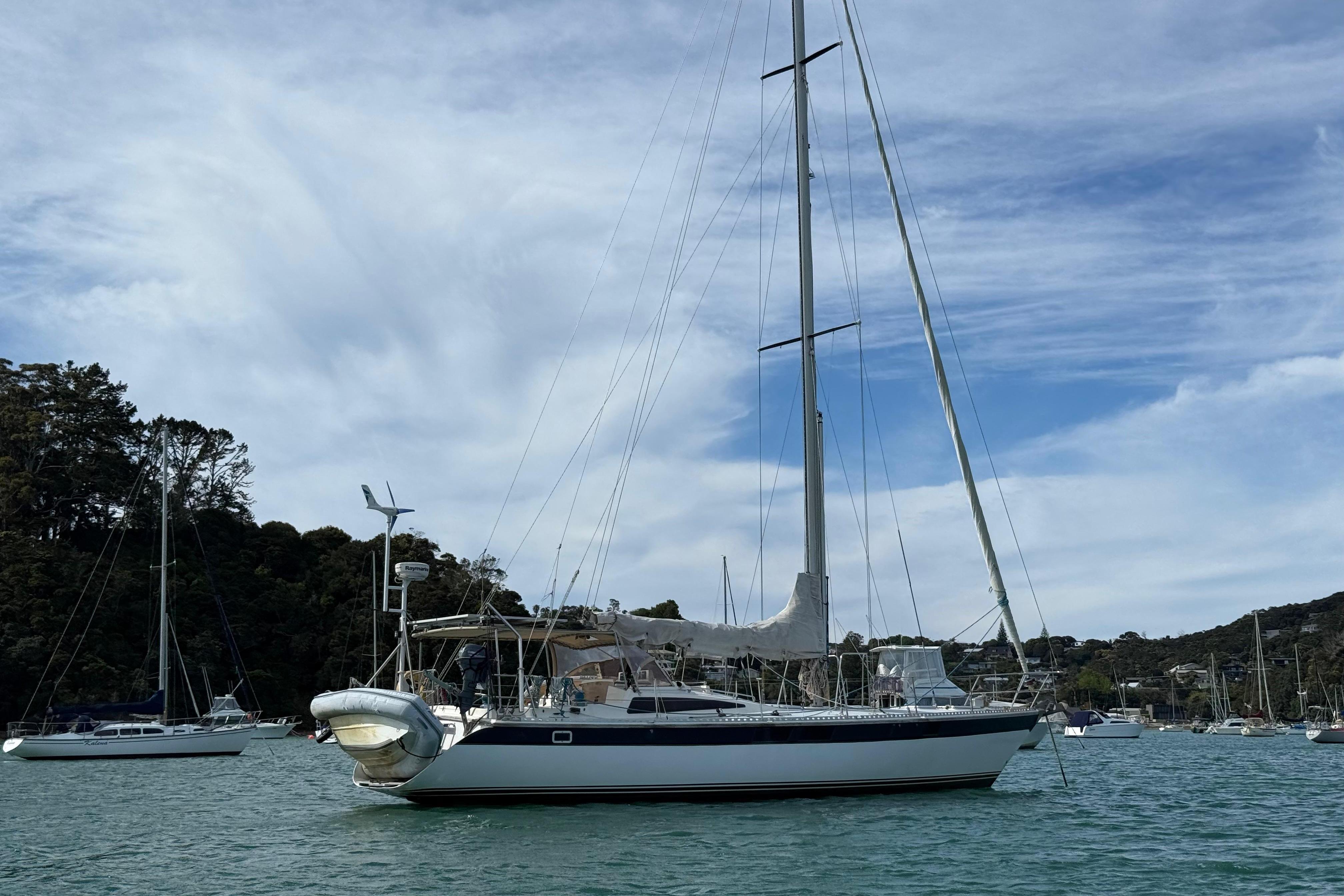 Sailboat Express 44 (1983) anchored in a scenic bay with other boats.